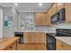 Kitchen with light wooden cabinets, dark countertops, and black appliances, with an island and hardwood floors at 1326 Fairview Club Dr, Wake Forest, NC 27587