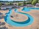 Aerial view of a community pool with a lazy river, splash pad, and lounge areas at 1326 Fairview Club Dr, Wake Forest, NC 27587