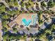 Aerial view of a community pool with a spacious deck and lounge area surrounded by trees, homes and parking at 1326 Fairview Club Dr, Wake Forest, NC 27587