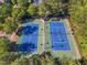 Aerial view of tennis courts surrounded by trees, with players enjoying a match on a sunny day at 1326 Fairview Club Dr, Wake Forest, NC 27587