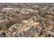 This aerial view captures a neighborhood with various roof colors, mature trees, commercial buildings, and sunny skies at 1603 N Alston Ave, Durham, NC 27701