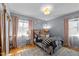 Bedroom with floral bedding, hardwood floors, two windows, and soft pink drapes at 1603 N Alston Ave, Durham, NC 27701