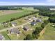 Wide aerial perspective of homes in a quiet suburban community surrounded by green fields and mature trees at 172 Fox Run Ct, Benson, NC 27504