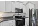 Kitchen featuring white cabinets, stainless steel appliances, granite countertops, and subway tile backsplash at 172 Fox Run Ct, Benson, NC 27504