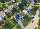 Aerial view of a charming home with a driveway and lush green lawn surrounded by mature trees at 1805 Abby Knoll Dr, Apex, NC 27502
