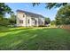 View of backyard, a large grassy expanse perfect for outdoor activities and entertaining, light colored siding at 1805 Abby Knoll Dr, Apex, NC 27502