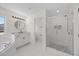 All-white bathroom offers a tub, walk-in shower, modern lighting, and ample storage at 1805 Abby Knoll Dr, Apex, NC 27502