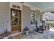 Cozy front porch features rocking chairs and stone flooring by a beautiful glass front door at 1830 Wilshire Ave, Raleigh, NC 27608