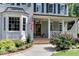 Inviting porch of a home featuring classic columns, meticulous landscaping, and brick entryway at 1830 Wilshire Ave, Raleigh, NC 27608