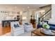 Open-concept living room and kitchen area featuring a fireplace, hardwood floors, and modern kitchen at 1830 Wilshire Ave, Raleigh, NC 27608