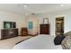 Main bedroom with a dresser, tv, and a peak at the ensuite bathroom and closet at 1830 Wilshire Ave, Raleigh, NC 27608