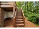 Image shows wooden stairs leading from the backyard to the upper deck at 208 Rockport Ridge Way, Cary, NC 27519