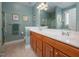Bathroom with double sinks, wooden cabinets, and decorative artwork at 208 Rockport Ridge Way, Cary, NC 27519