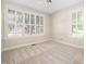 Bright bedroom featuring neutral carpet, shuttered windows, and a ceiling fan at 208 Rockport Ridge Way, Cary, NC 27519