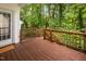 A view of a brown stained wooden deck, greenery visible beyond the wooden railing at 208 Rockport Ridge Way, Cary, NC 27519