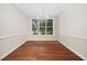 Bright dining room with hardwood floors and a view of the outdoors through the large window at 208 Rockport Ridge Way, Cary, NC 27519