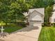 Well-manicured lawn and mature trees surround this charming home featuring a two-car garage at 208 Rockport Ridge Way, Cary, NC 27519