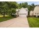 Attractive home with a lush green lawn, mature trees, and a spacious two-car garage at 208 Rockport Ridge Way, Cary, NC 27519