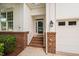 Inviting front entrance featuring brick accents, stairs, and a covered porch area at 208 Rockport Ridge Way, Cary, NC 27519