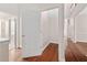 Hallway with hardwood floors, white doors, and staircase in the background at 208 Rockport Ridge Way, Cary, NC 27519