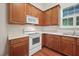 Kitchen with wooden cabinetry, a range, and ample countertop space at 208 Rockport Ridge Way, Cary, NC 27519