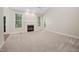 Spacious living room featuring a fireplace, large windows, and neutral carpeting at 208 Rockport Ridge Way, Cary, NC 27519