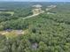 An aerial view showcasing the property's location surrounded by lush trees, homes, and a highway at 2095 Woodberry Dr, Clayton, NC 27527