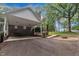 Home featuring a carport and outdoor fire pit surrounded by mature trees and landscape at 2095 Woodberry Dr, Clayton, NC 27527