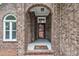 Close-up of front entrance with brick archway, concrete stoop, and a decorative front door at 2095 Woodberry Dr, Clayton, NC 27527