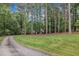 Brick home nestled among mature trees with a large front yard and long driveway at 2095 Woodberry Dr, Clayton, NC 27527