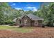 Brick residence showcasing arched windows, manicured greenery, and a well-maintained lawn at 2095 Woodberry Dr, Clayton, NC 27527