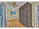 Hallway with a brick accent wall, hardwood floors, and beach themed decor at 2095 Woodberry Dr, Clayton, NC 27527