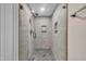 Modern shower features gray stone-look tiling with pebble flooring and glass surround at 2095 Woodberry Dr, Clayton, NC 27527