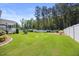 Lush backyard with a well-manicured lawn and white fence at 2223 Copper Pond Way, Fuquay Varina, NC 27526