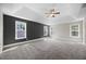 Large bedroom featuring a tray ceiling, a ceiling fan, multiple windows, and neutral paint at 2223 Copper Pond Way, Fuquay Varina, NC 27526