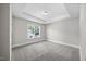 Clean bedroom with grey walls, carpet flooring, a window and a tray ceiling at 2223 Copper Pond Way, Fuquay Varina, NC 27526