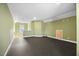 Expansive bonus room featuring green walls, dark carpet, and natural light from the window at 2223 Copper Pond Way, Fuquay Varina, NC 27526