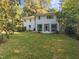 The backyard has a white house with a screened-in porch and lots of green grass at 227 W Drewry Ln, Raleigh, NC 27609