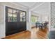 Inviting foyer with decorative wallpaper, black double doors, and hardwood floors leading into the dining room at 227 W Drewry Ln, Raleigh, NC 27609