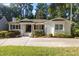 Charming one-story home featuring a white brick exterior, manicured landscaping, and a welcoming covered front porch at 227 W Drewry Ln, Raleigh, NC 27609