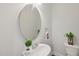 Powder room featuring a pedestal sink, round mirror and decorative accents at 2323 Pindos Dr, Cary, NC 27519
