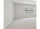 Bright bedroom features neutral carpet, white walls, and natural light from a window at 2323 Pindos Dr, Cary, NC 27519