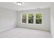 Carpeted bedroom with three large windows overlooking lush trees at 2323 Pindos Dr, Cary, NC 27519