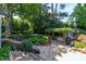 Beautiful backyard featuring a stone patio, pergola, grill, and lush greenery at 2707 Anderson Dr, Raleigh, NC 27608