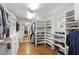 Walk-in closet featuring custom shelving, mirror, and hardwood floors at 2707 Anderson Dr, Raleigh, NC 27608