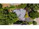 An aerial view of a home with a gray roof, surrounded by lush greenery and a paved driveway at 2707 Anderson Drive Dr, Raleigh, NC 27608
