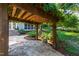 Landscaped backyard with a stone pathway under a wooden pergola, leading to the home's exterior at 2707 Anderson Drive Dr, Raleigh, NC 27608
