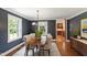 Chic dining room with navy walls, a contemporary light fixture, and hardwood flooring at 2707 Anderson Drive Dr, Raleigh, NC 27608