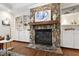 Close up of a stone fireplace with built in shelves and wood mantle at 2707 Anderson Drive Dr, Raleigh, NC 27608