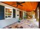 Covered front porch with stone flooring, wooden ceiling, fan, and seating area with exterior lighting at 2707 Anderson Drive Dr, Raleigh, NC 27608